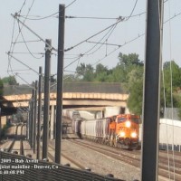 BNSF 5983 and 5872 lead a unit grain train south over "the Hump" along Denver's BNSF/UP joint mainline. The catenary visible in the foreground is the RTD light rail commuter line.