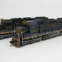 Two of my latest Kato SD45's that I backdated to the earlier "switcher" scheme. I overpainted the factory Rio Grande logo and nose > redecalled both
I've also worked out that it's easier to weather my locos with the shell / fuel tank / truck sideframes separate from the chassis > saves time by not having to mask wheels + pick ups.
I also tried something for the first time my last 5-6 SD45's & used a microbrush to apply Neolube to the brass lug & pick up strip blackening them & making them virtually invisible