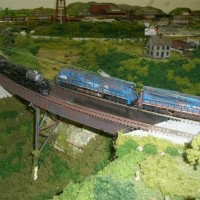 Old meets new.  Athearn Challenger and a Kato Conrail SD pass on the plate girder bridge.
