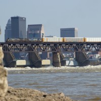 CSXT Q268, A northbound autorack train on the LIRC crosses the "Falls Of The Ohio" with downtown Louisville, KY in the background.
