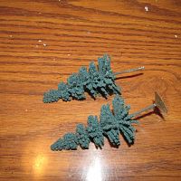 Trees come with plastic bases.  I removed the bases to plant in foamboard.