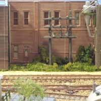 Sand Springs Railway - Power poles on window backdrop. buildings kitbashed, poles scratch built.