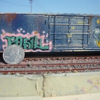 5
 I hand paint and airbrush one of a kind scale freight cars based on actually 'tagged' cars.  Each are aged and weathered to various degrees, and the graffiti is airbrushed (No Decals) . This photo batch are all HO scale and photographed outdoors in Long beach harbor area on a small diorama. A quarter  placed in photo shows scale.