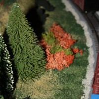 Some trees and bushes between the mainline and the lumber yard siding