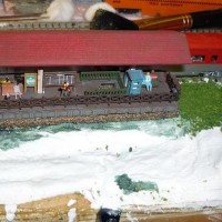 Kitbashed remote pick up station outside the town of Sauk. Underground tunnel makes a walkway under the rails from the main town depot. This seconds as a tourist "lookout" point overlooking a rock ledge and towards the river...
