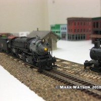 A freight extra meets a Passenger train just pulling into the station at McKibben.