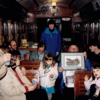 This would have been his 79th birthday party, aboard car 300, which was at the time the Willamette Shore Trolley. A younger SD74 is to his right.