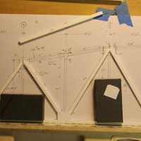 Step 3 - Side trusses (matching pairsm) are built up on the drawing.  The bottom chord is continuous, 426 feet long.  In N scale it comes out to 32 inches in the layout room.  I used a four foot level for a straight edge and build it on a glass sheet for flatness.
