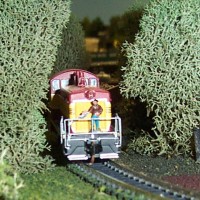 Crewman with chain saw to remove overgrown tree branches along the ROW